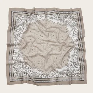 Close-up detail of a square floral print scarf featuring elegant wavy laser-cut edges.