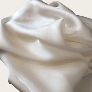 Close-up of elegant milky white silk scarf showing soft luster and fabric texture