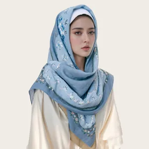 Detailed close-up of a blue floral voile hijab with scalloped wave edges for women