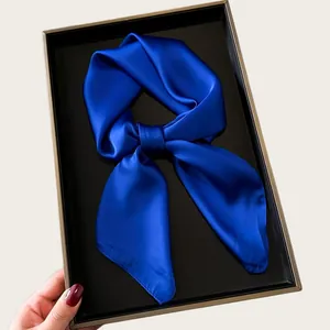 Elegant royal blue silk satin square scarf tied in a bow inside a black gift box