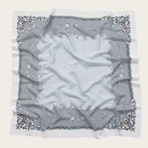 Close-up detail of a floral print square scarf featuring delicate wavy scalloped edges