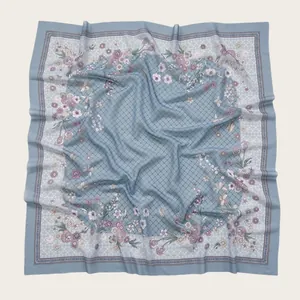 Detailed view of light blue floral print square scarf with wave-cut edges and voile fabric