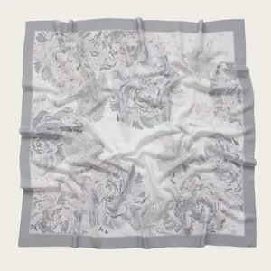 Macro view of floral print square scarf with elegant gray border and wavy edges