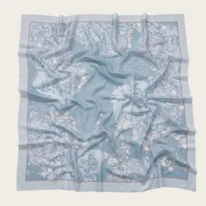 Detailed macro view of square scarf with light blue floral print and wavy cut edges