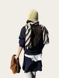 Vista trasera de una mujer con una bufanda de cebra y un gorro de punto amarillo.