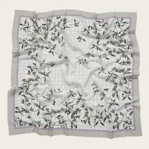 Close-up detail of a soft floral print square scarf featuring delicate wavy cut edges.