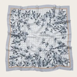 Detail view of the square voile scarf showing elegant floral prints and wave-cut edges.