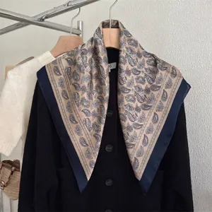 Primo piano di un foulard in seta con motivo paisley vintage su un cardigan nero