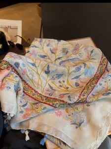 Detailed view of lightweight summer floral scarf with blue and pink tassels