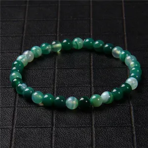 Detailed macro view of 6mm green natural stone beaded bracelet with cat's eye effect