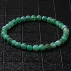 Detailed view of 6mm natural green stone beads on a single strand stretch bracelet