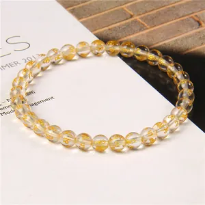 Close-up of clear 6mm beads with gold mantra engravings on this elegant bracelet