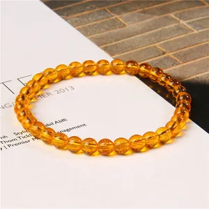 Close-up of 6mm amber cat's eye stone beads with gold mantra engravings