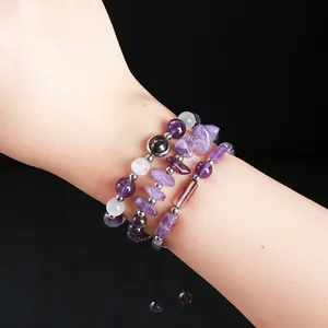 Set of natural amethyst chip and beaded bracelets on a wrist for a boho look.