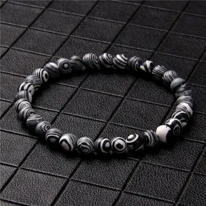 Macro view of a 6mm beaded bracelet featuring unique black and white stone swirl patterns