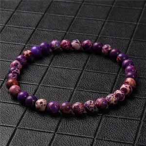 Close-up of a 6mm purple marbled stone bead bracelet on a textured grid background