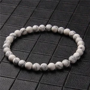 Macro view of white howlite stone bead bracelet featuring natural grey marble texture