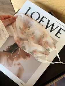 Gros plan montrant le motif de rose élégant et la texture en maille de ce masque