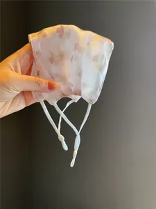 Vue détaillée d'un masque solaire en résille fleurie avec boucles d'oreilles