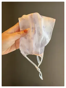 Vue détaillée du masque facial respirant en maille à imprimé floral avec boucles