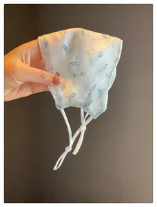 Vue détaillée du masque solaire respirant en maille avec imprimé floral délicat
