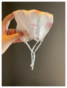 Vue détaillée d'un masque de soleil floral en maille avec lanières blanches réglables