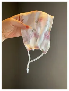 Gros plan sur un masque facial respirant en maille avec imprimé floral pour l'été.