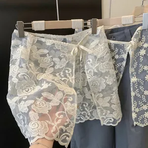 Dettaglio del ricamo floreale bianco sul pannello della gonna in organza velata