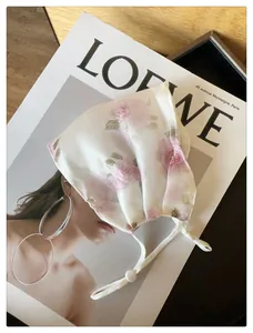 Détail d'un masque de protection solaire en maille respirante avec imprimé floral rose vintage