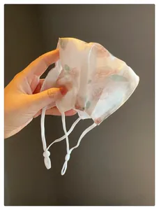 Vue détaillée du masque solaire en maille respirante avec imprimé floral et boucles réglables