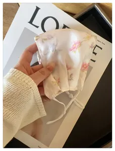 Détail d'un masque solaire respirant en maille à fleurs avec sangles réglables