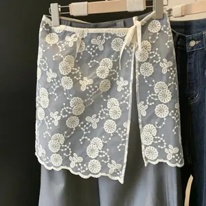 Vista dettagliata del ricamo floreale su una gonna in organza trasparente per sovrapposizione