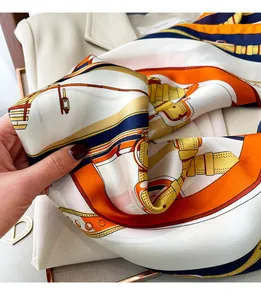 Nahaufnahme eines luxuriösen Seidenschals mit elegantem orange-navyfarbenem Reitsport-Muster