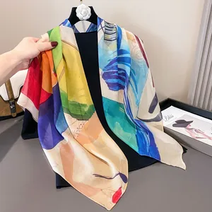 Primer plano de un gran pañuelo cuadrado de satén con estampados artísticos abstractos.