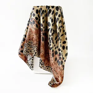 Close-up of leopard print satin square scarf showing its elegant silky texture and drape.