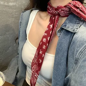 Elegante sciarpa sottile con motivo paisley rosso indossata come un foulard da collo
