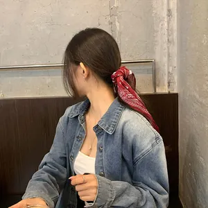 Foulard per capelli rosso paisley annodato in una coda di cavallo bassa su modella