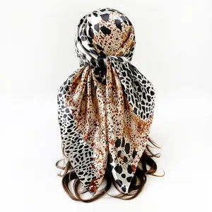 Detailed view of a leopard print satin square scarf styled as a fashion headscarf on a model