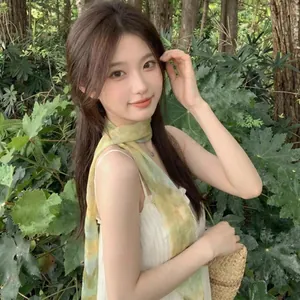 Primo piano di un fresco foulard di seta giallo-verde indossato da una modella asiatica fuori.