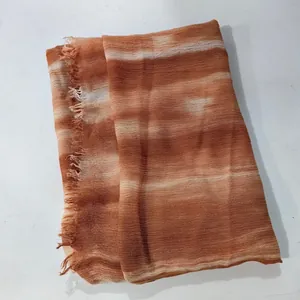 Close-up of gradient orange crinkled scarf with pleated texture and fringe edges