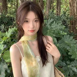Dettaglio di un foulard in seta acquerello verde e giallo indossato da una modella
