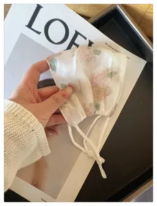 Détail du masque de protection solaire respirant en maille avec imprimé floral et sangles réglables