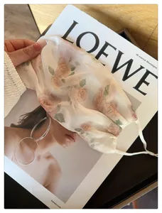 Gros plan sur l'imprimé floral délicat et la texture en maille respirante du masque