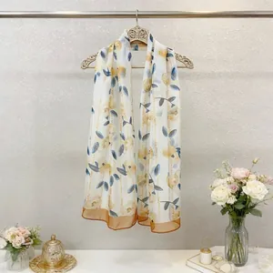 Floral georgette scarf hanging on a vintage hanger with a flower vase background