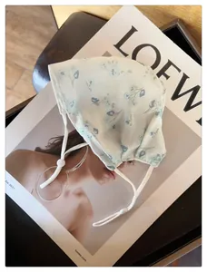 Gros plan d'un masque solaire en mesh respirant avec des imprimés floraux bleus pour l'été