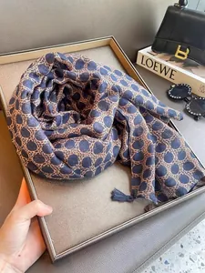 Detail showing a navy polka dot and leopard print lightweight silk scarf with small tassels
