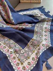Close-up of navy blue scarf with geometric ethnic pattern and decorative tassels