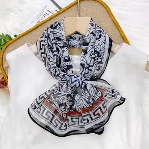 Elegant thin silk scarf with floral and geometric patterns shown on a white dress.