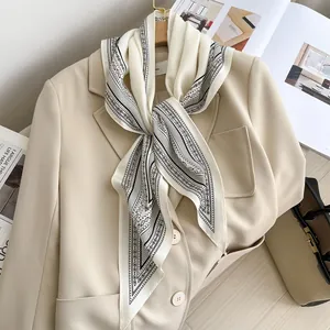 Vintage paisley print silk triangle scarf draped on a beige blazer for a chic look