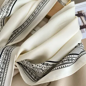 Close-up detail of white silk scarf with black paisley cashew flower print pattern